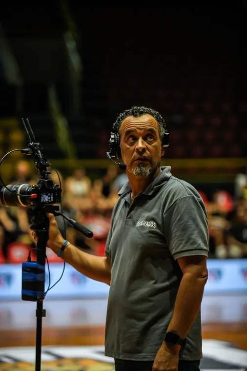 Profissional com headset e microfone à beira da quadra